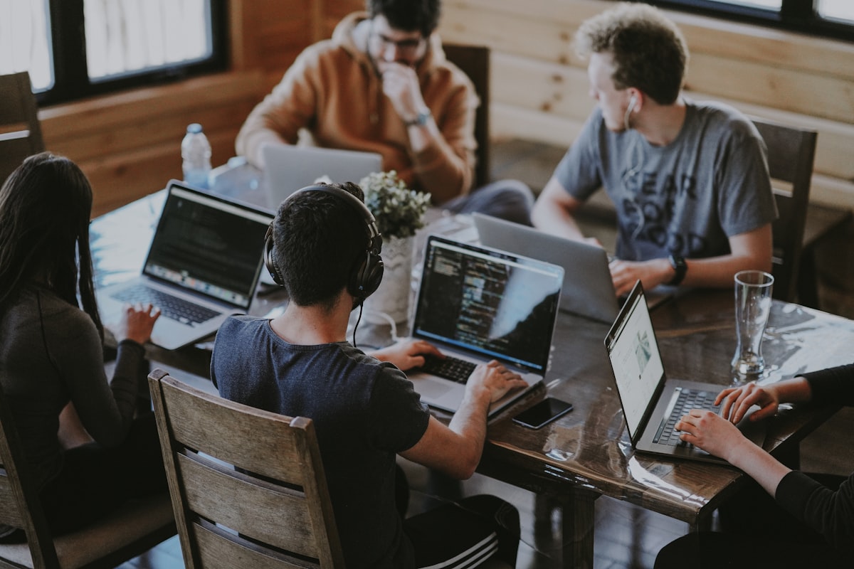 A team working together on laptops around a shared table